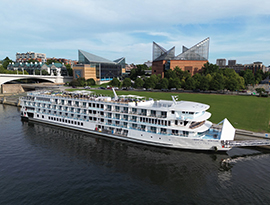 The American Serenade docked alongside Chattanooga, TN with a ramp extended to the dock from its bow allowing easy boarding and unboarding.