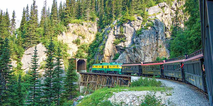 Train crossing a wooden bridge during an American Cruise Lines Alaska excursion