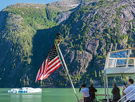 Passengers photographing Alaska mountains and ice from a small cruise ship