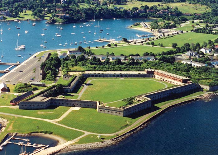 Aerial view of cruise excursion, Fort Adams, surrounded by water, green lawns, and a marina with small boats.