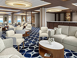 The River Lounge, a common area on American Encore with several small tables with grey and red armchairs surrounding them on red and white patterned carpet. Along the center part of the back wall, there is a grand piano. There are also floor-to-ceiling windows on the left wall with views of the Columbia River.