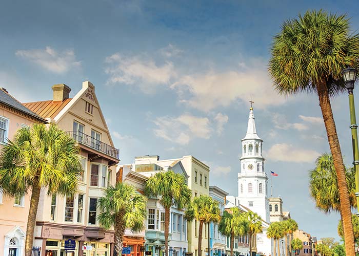 Historic, Rainbow Road in Charleston with buildings of different colors and large white steeple